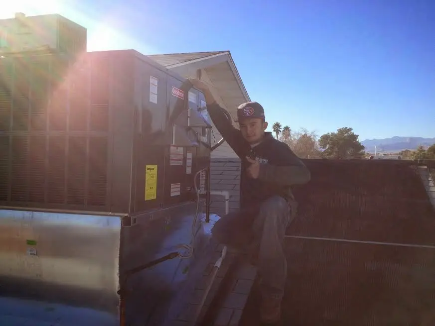 HVAC technician performing HVAC Inspection on a rooftop unit in Lino Lakes